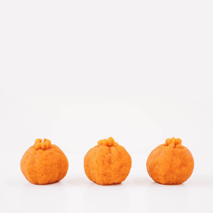 Beeswax mandarin orange candle by Happy Organics on a natural surface