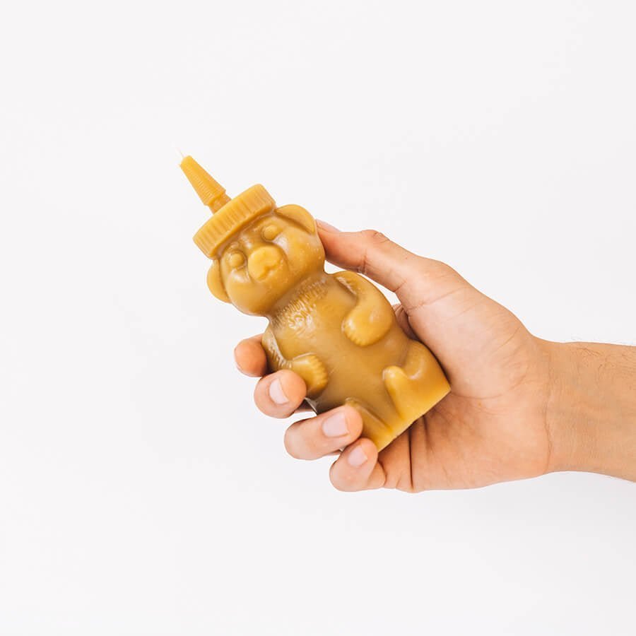 Beeswax honey bear candle by Happy Organics burning with a warm golden flame