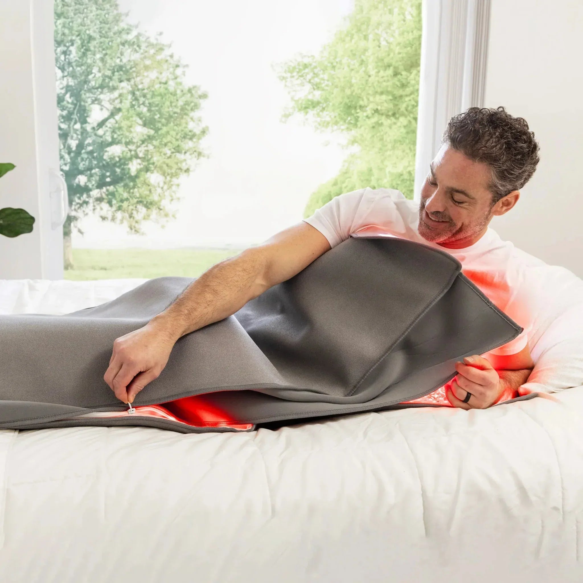 Man lying inside the Novaa Recovery Pod by NovaaLab with red light therapy glow visible