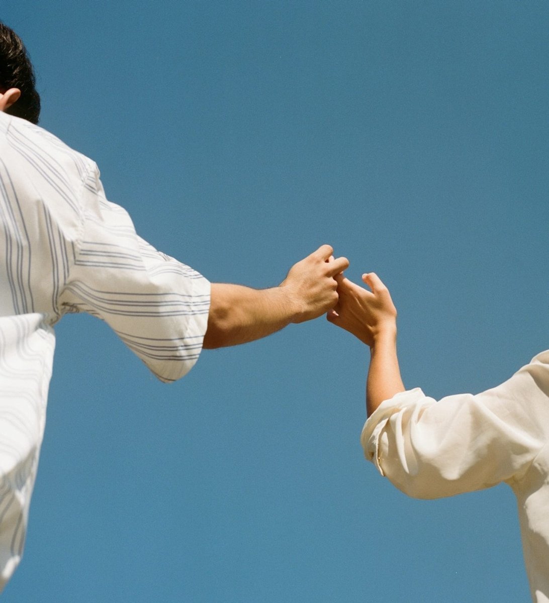 man and woman holding hands against a blue background for valnetines's day guide on nanaka.co