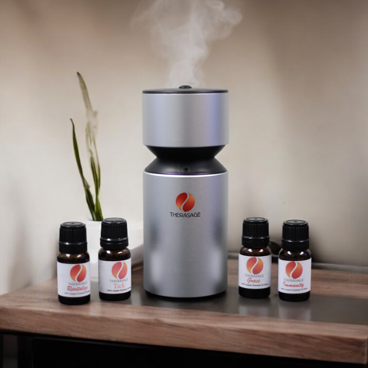 Therasage TherAroma diffuser misting on a wooden table beside four essential oil bottles