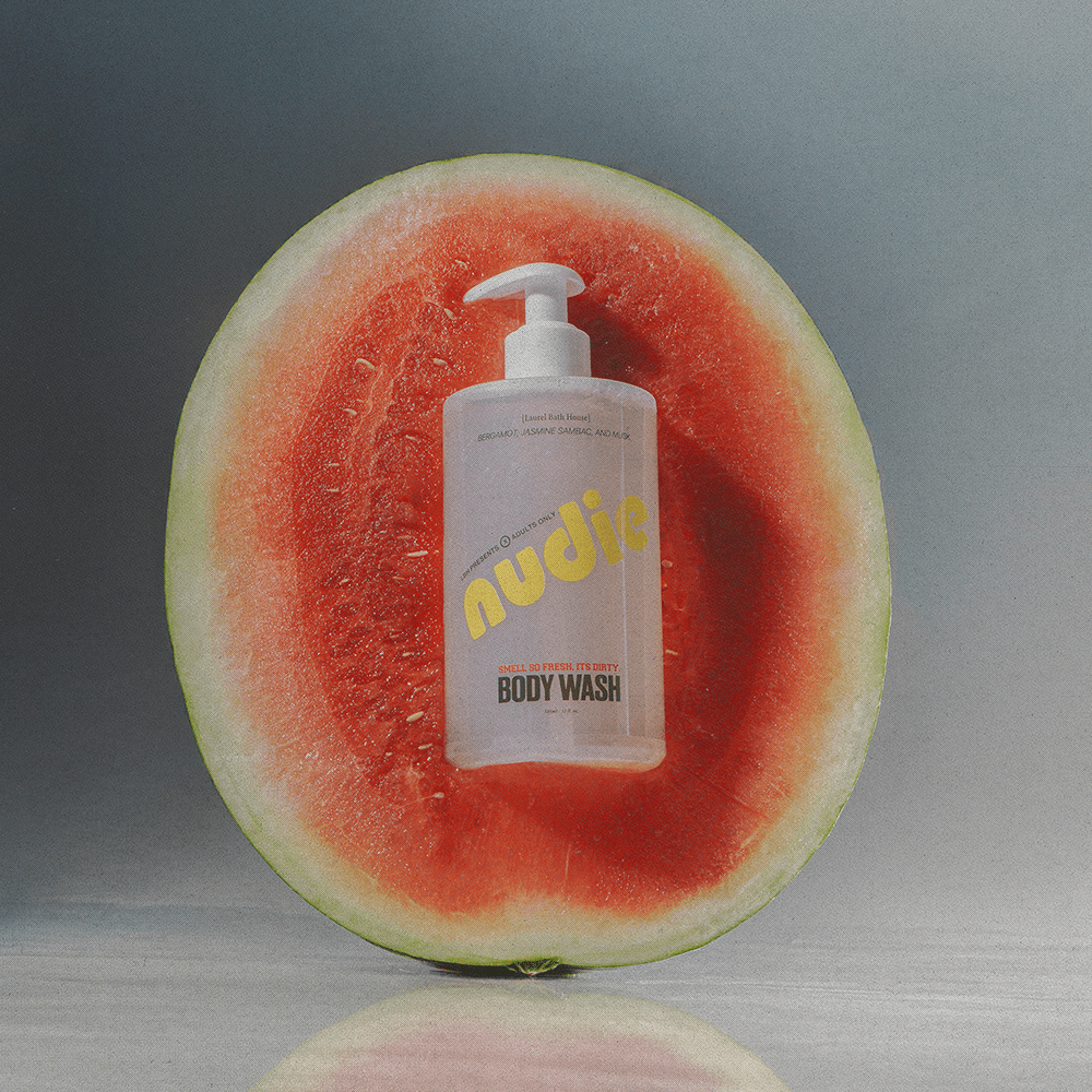 Laurel Bath House Nudie body wash bottle resting on a halved watermelon