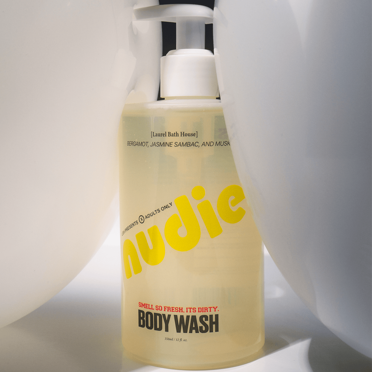 Laurel Bath House Nudie body wash bottle between white curtains