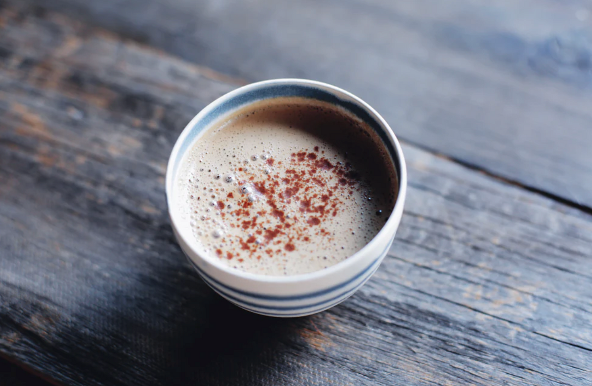 Cup of frothy ashwagandha latte dusted with cinnamon, made with Sun Potion Ashwagandha