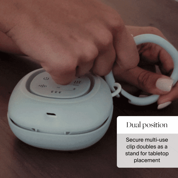 Hand unclipping the Canopy Sound Machine + Aroma: the multi-use clip doubles as a tabletop stand