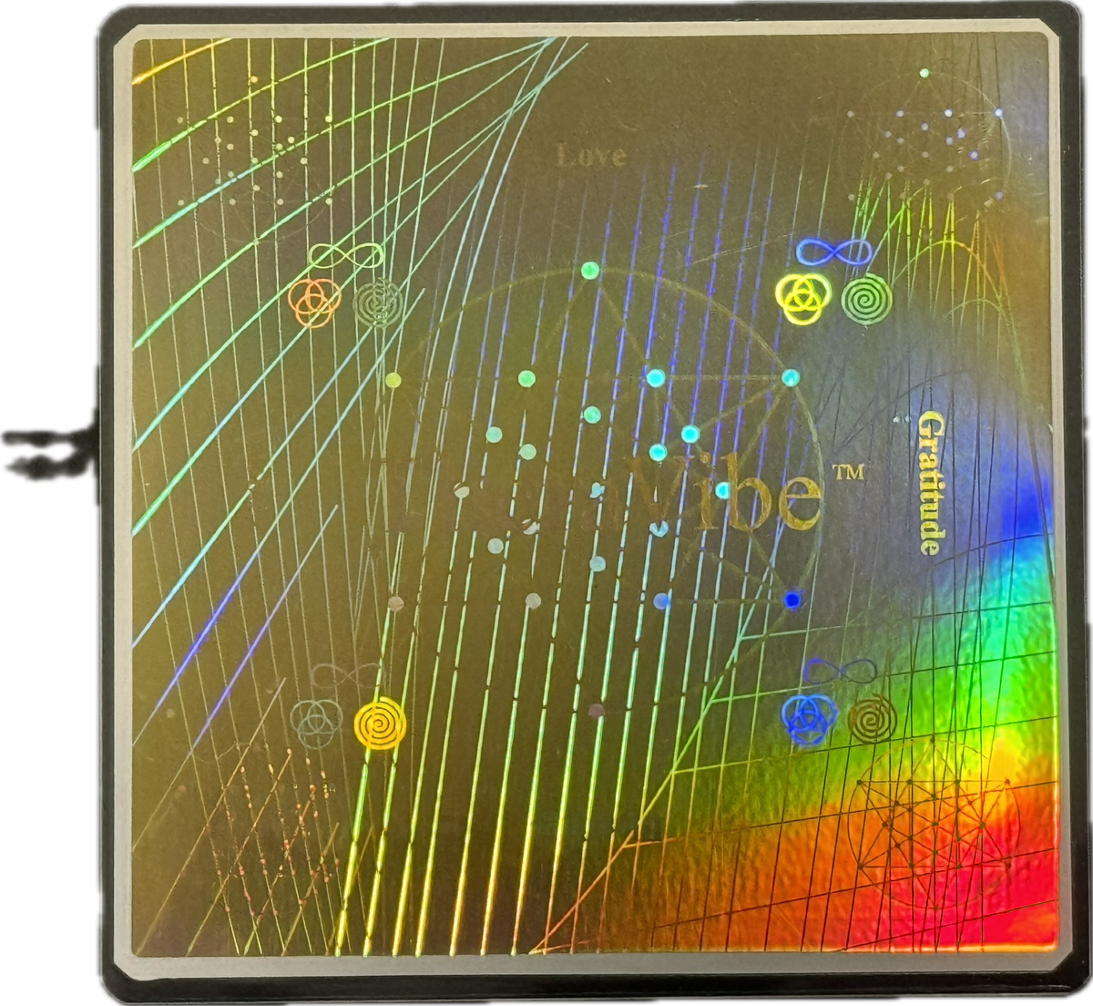 Close-up of a holographic Therasage TheraVibe Sleep Card with rainbow reflections