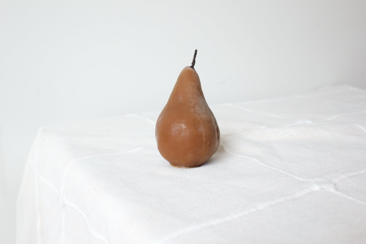 Brown pear shaped candleon a white surface - Happy Organics