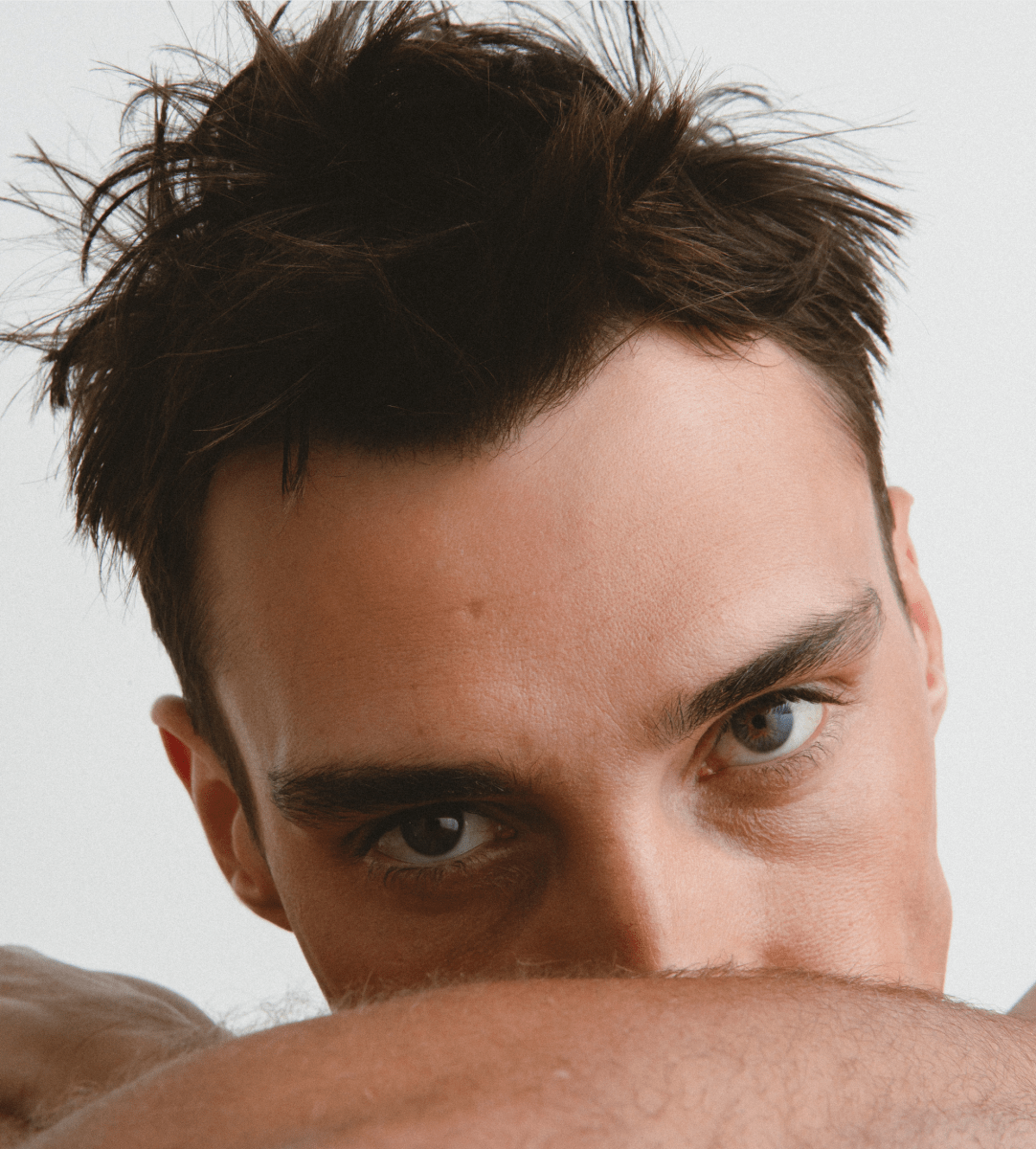 Close-up of a man's face with tousled textured hair styled with Jack Henry Hair Powder