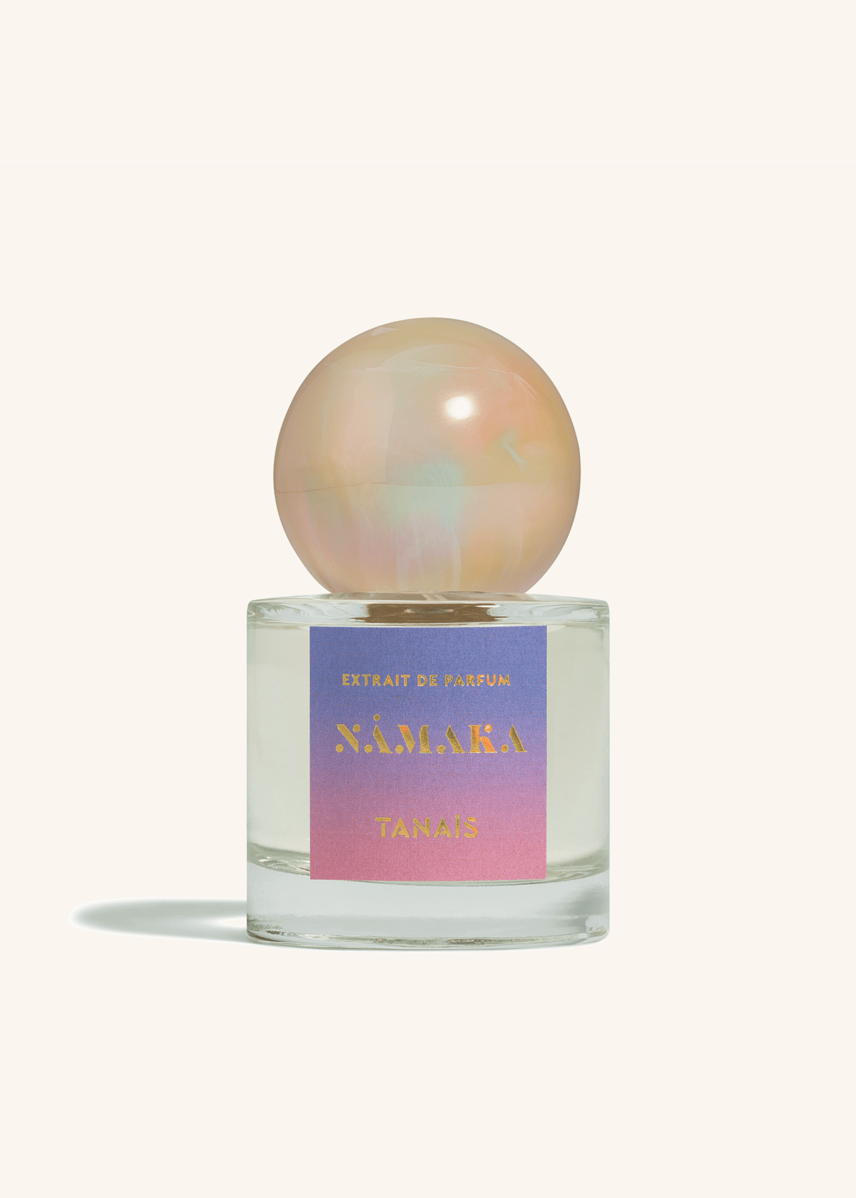TANAÏS Nāmaka Extrait de Parfum bottle with an opalescent pearl cap on a cream background