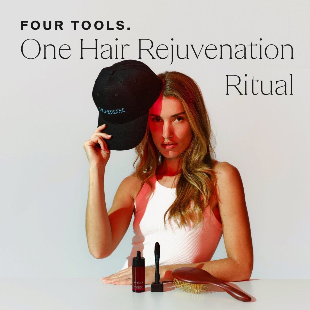 Woman with the HigherDOSE Red Light Hat and hair tools on a table: four tools, one hair rejuvenation ritual