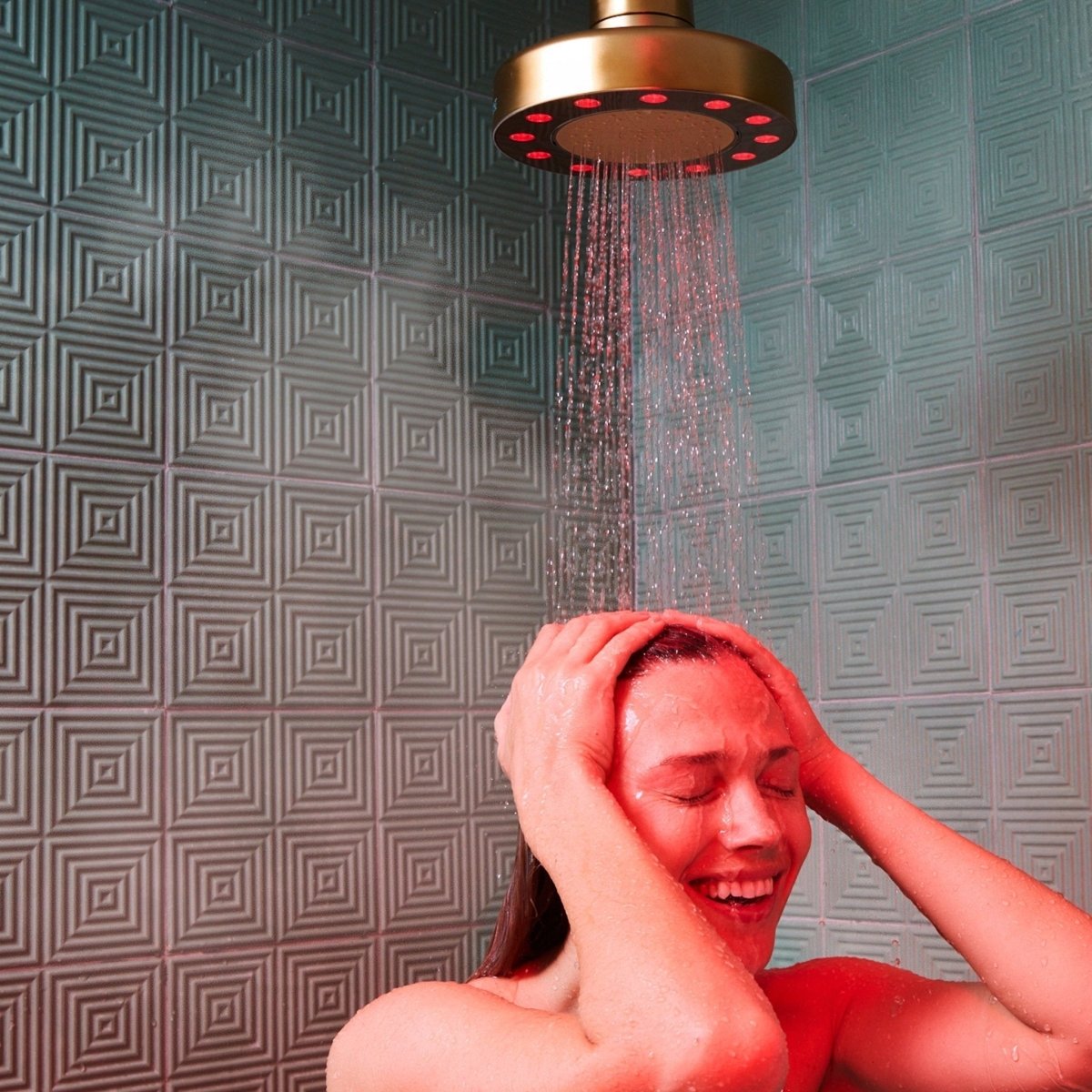 Woman washing her hair under a HigherDOSE Red Light Showerhead Filter on a tiled wall