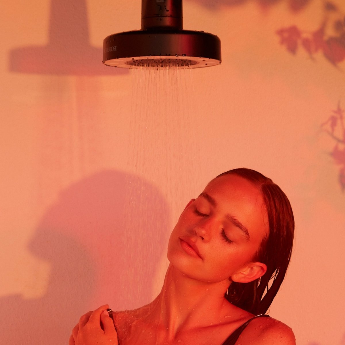 Woman with her eyes closed in the shower beneath the HigherDOSE Red Light Showerhead Filter