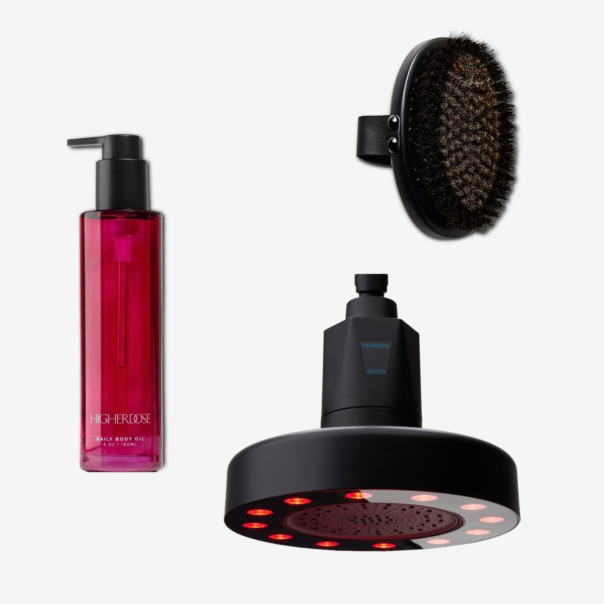 Black HigherDOSE Red Light Showerhead Filter with the Daily Body Oil and the copper body brush on white