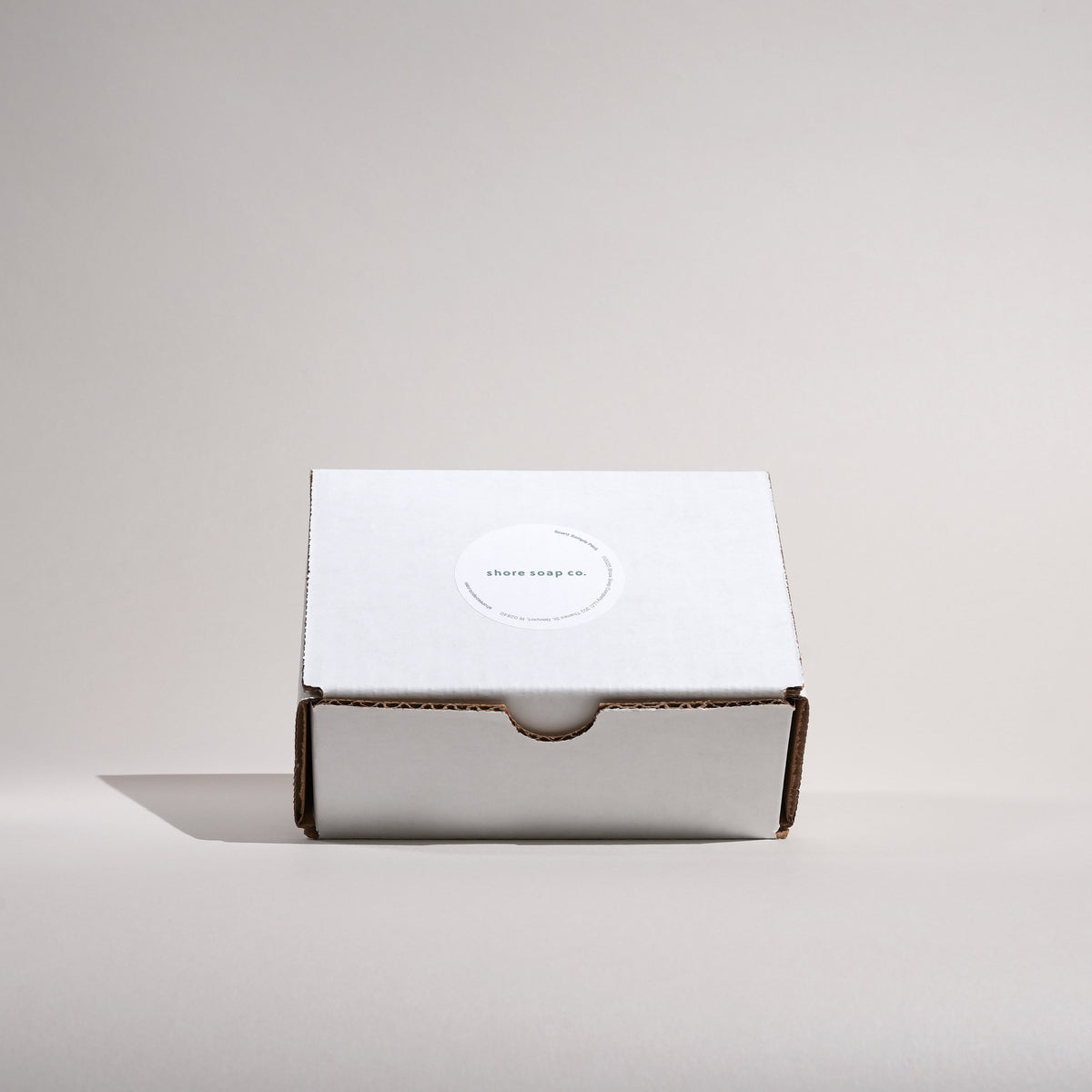Shore Soap Co. Scent Sample Pack closed white shipping box with a Shore Soap Co. seal