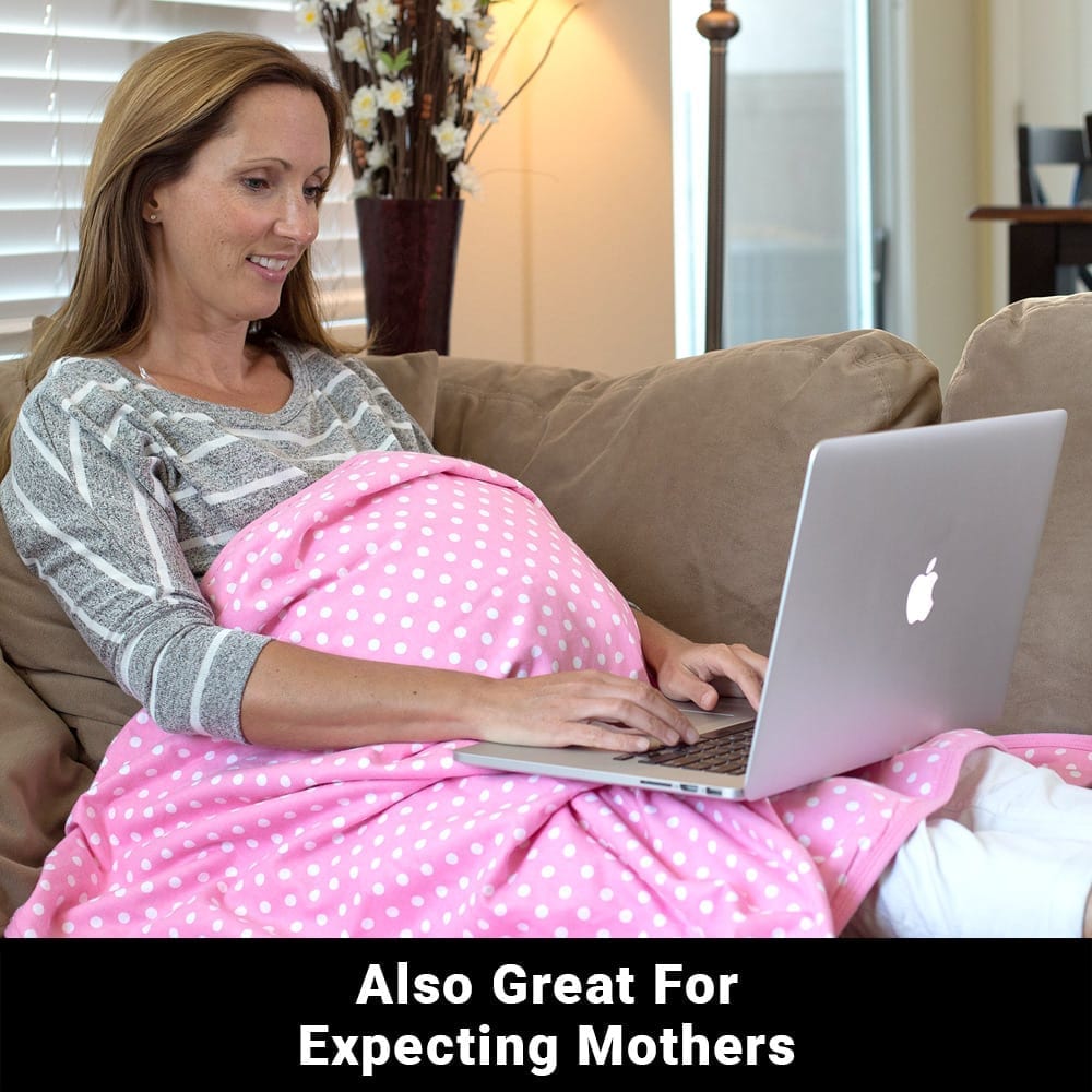 Pregnant woman using a laptop under a pink polka dot Shield Your Body Baby Blanket: also great for expecting mothers