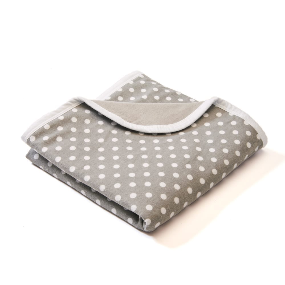 Shield Your Body Baby Blanket in gray polka dots folded over a white trim