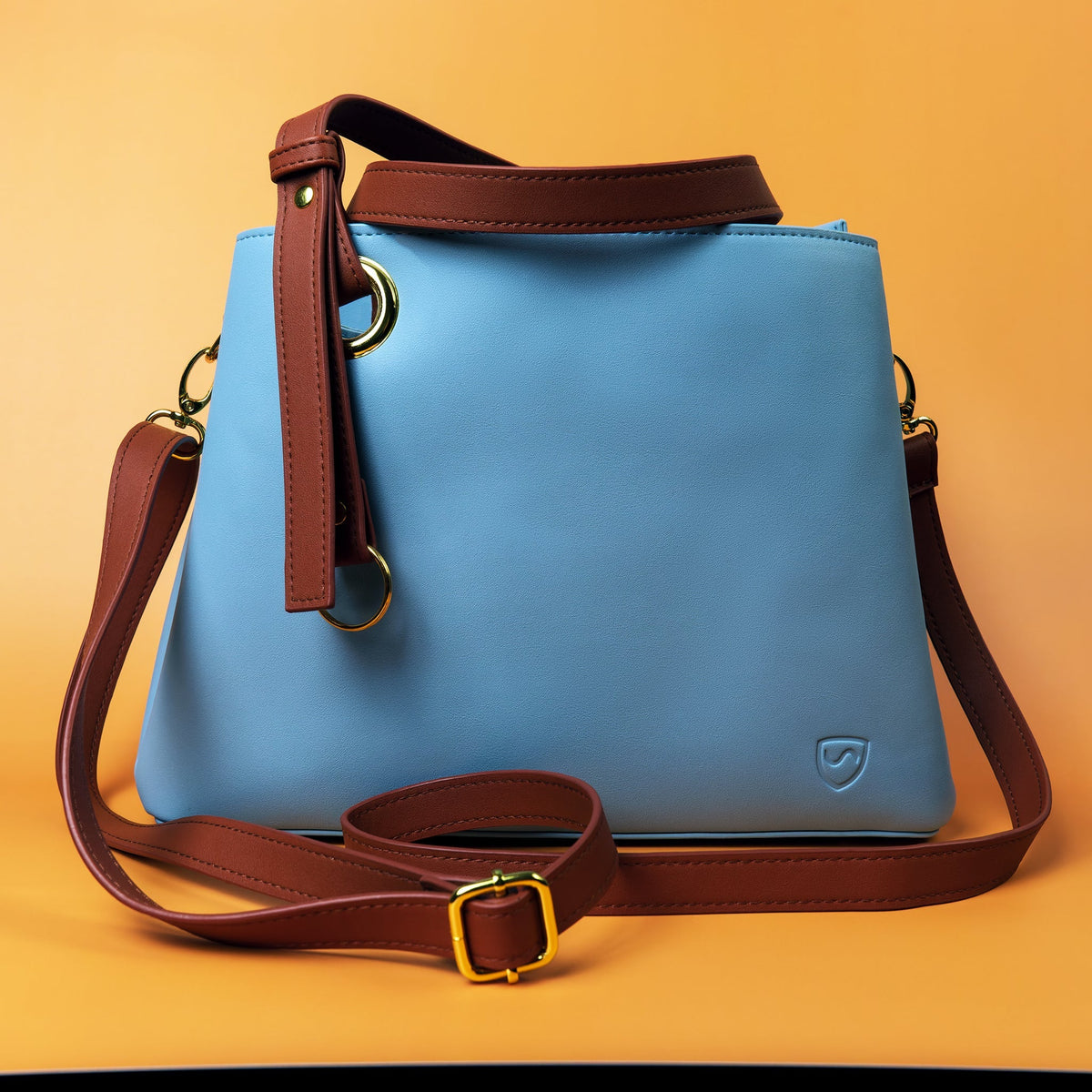 Shield Your Body blue Purse with crossbody strap on an orange background