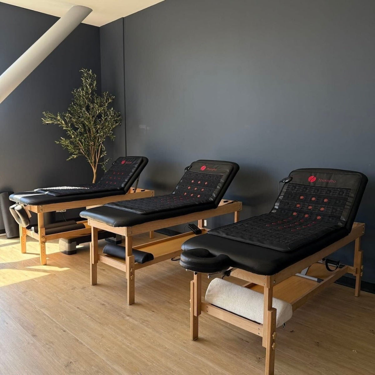 Several massage tables set up with Therasage TheraPro pads in a treatment room