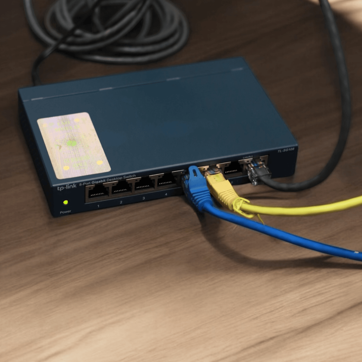 Therasage TheraProtect EMF protection sticker on a network switch with ethernet cables plugged in