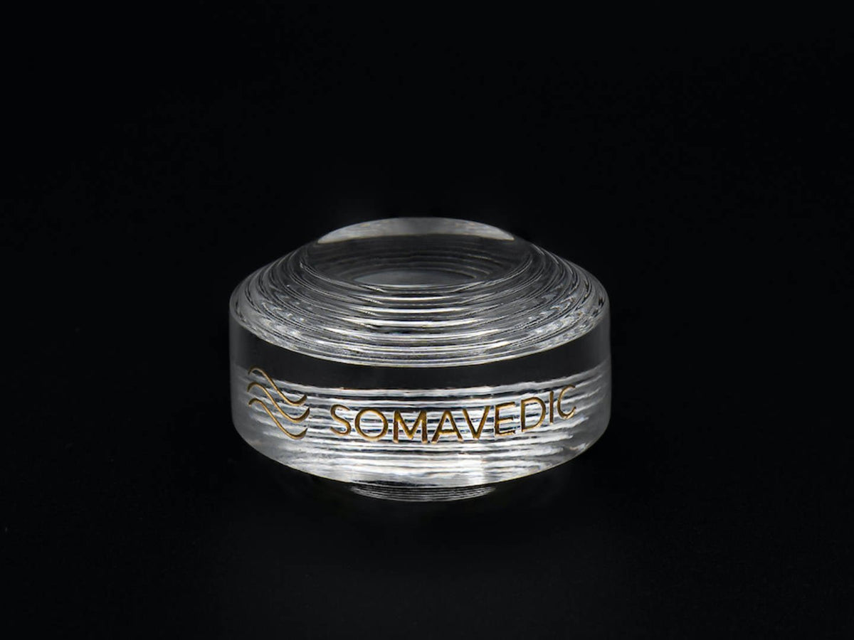 Somavedic Tiny in clear glass on a black background