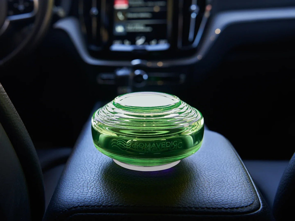 Somavedic Traveller with a green glow on a car armrest at night