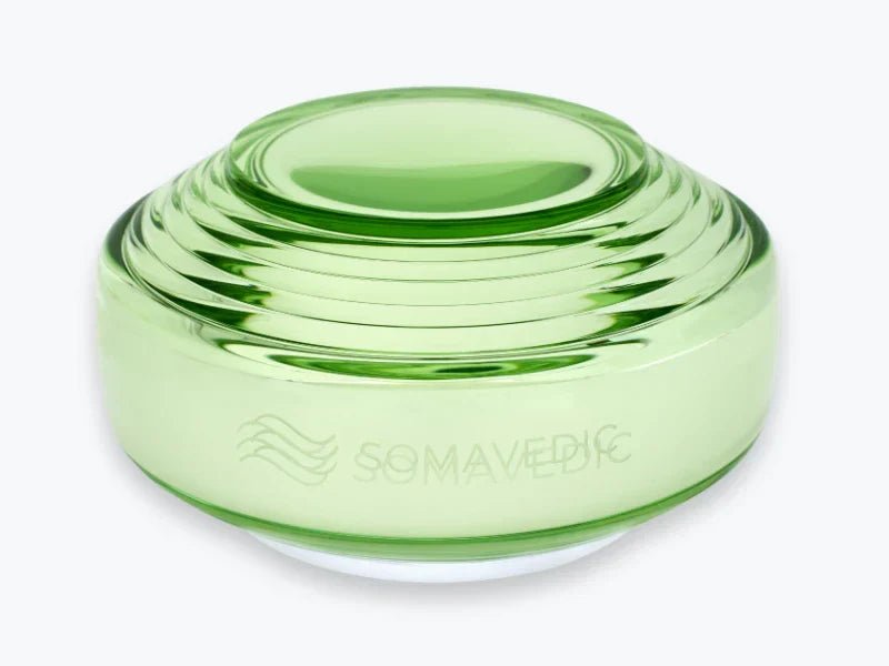 Green cosmetic container with 'Somavedic' branding on a white background
