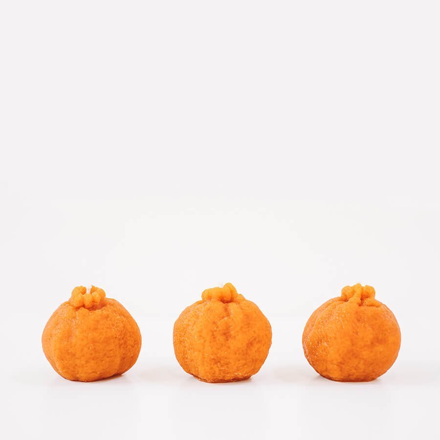 Beeswax mandarin orange candle by Happy Organics on a natural surface