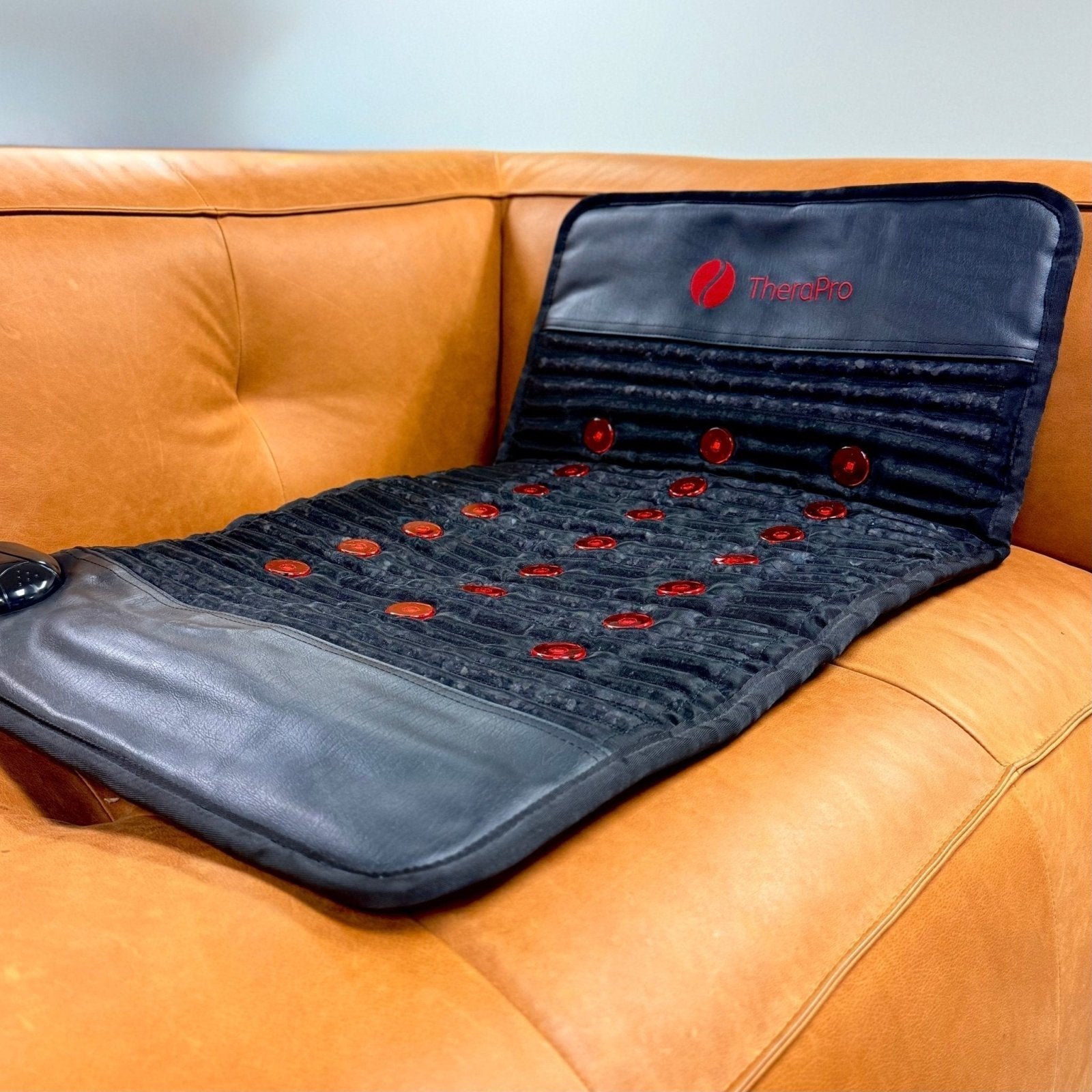 Therapro PEMF therapy mat on tan leather couch