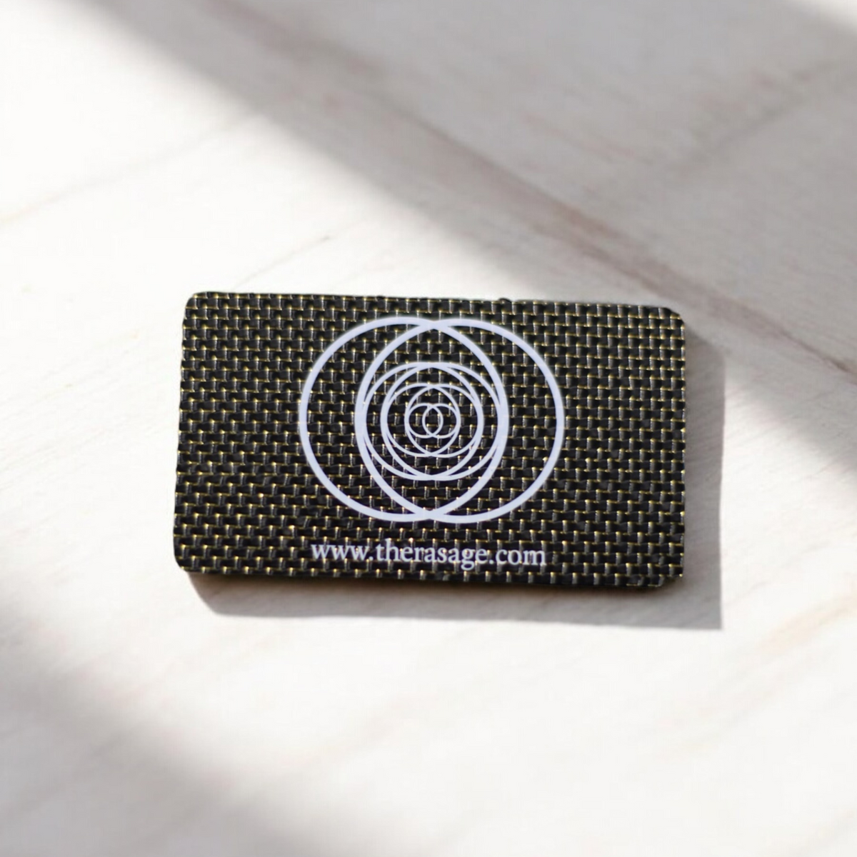 Therasage TheraVibe Quantum Card in black carbon weave with concentric circle logo on a white surface