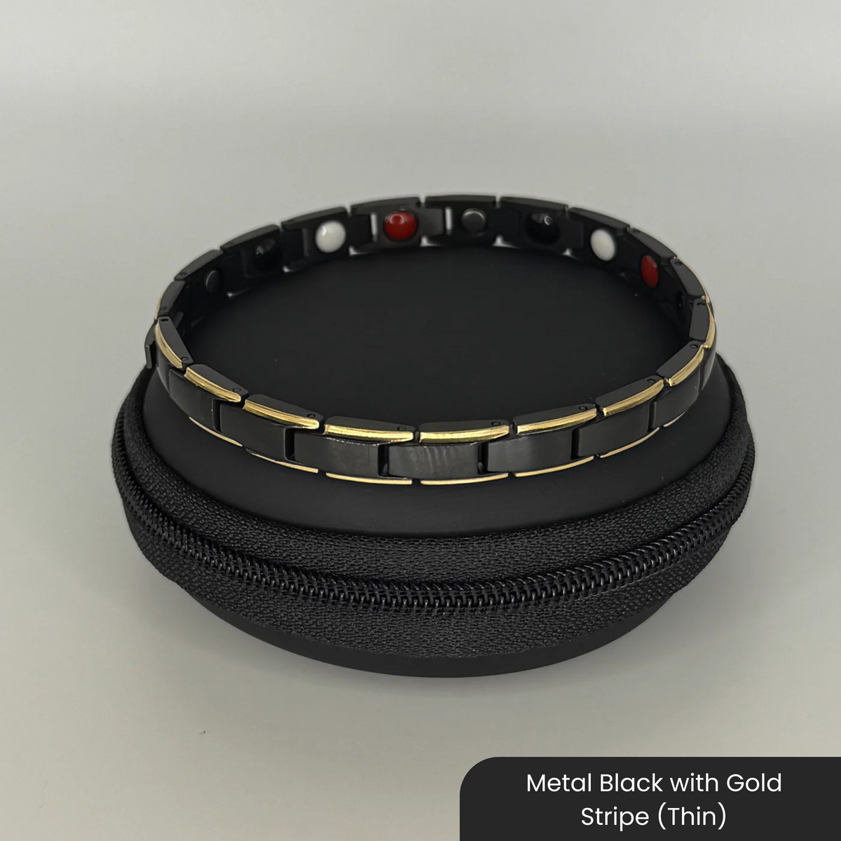Therasage Bio Band metal bracelet in Metal Black with Gold Stripe (Thin) on a black zip case