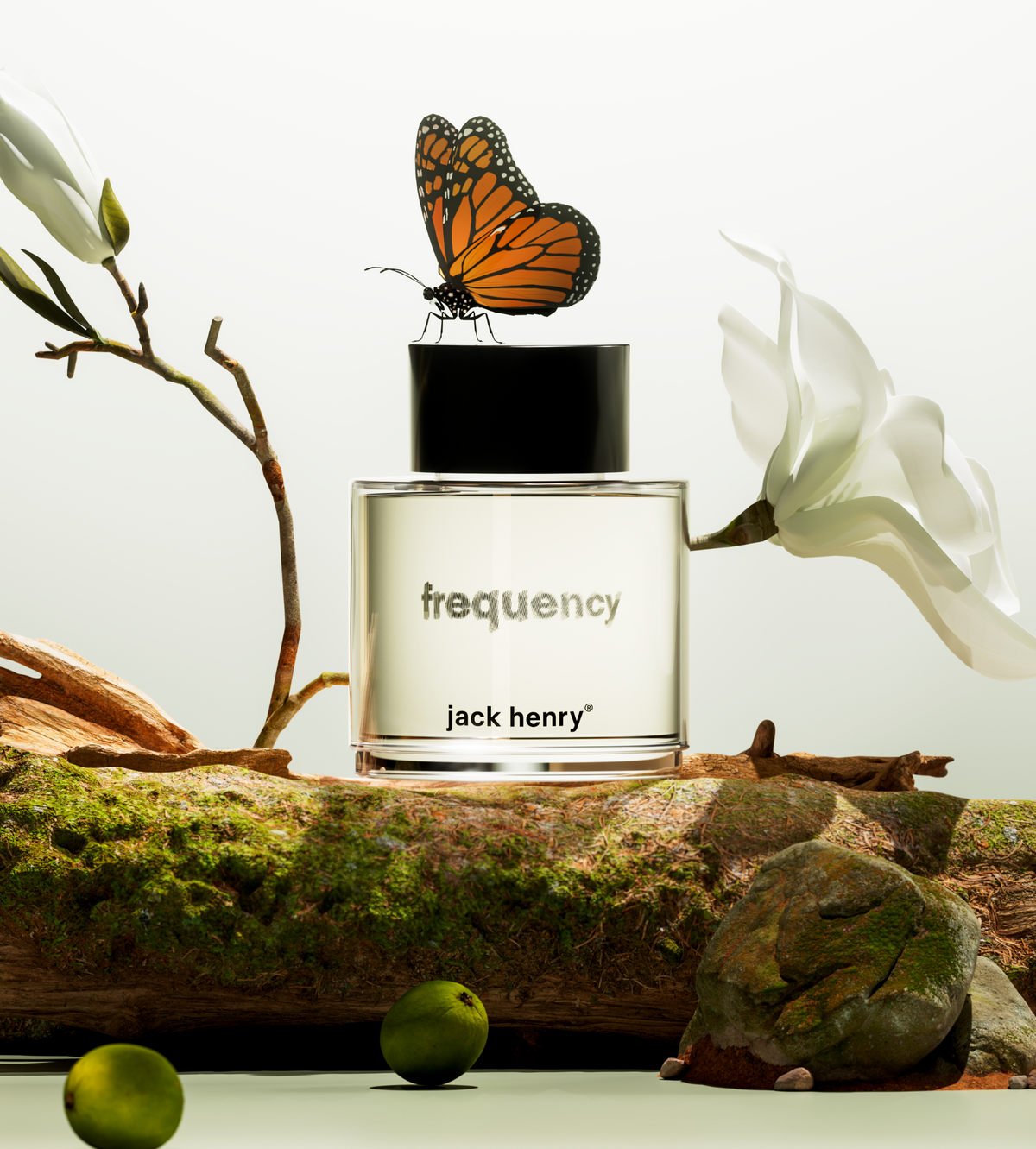 Jack Henry Frequency bottle on a mossy log with a monarch butterfly and white magnolia