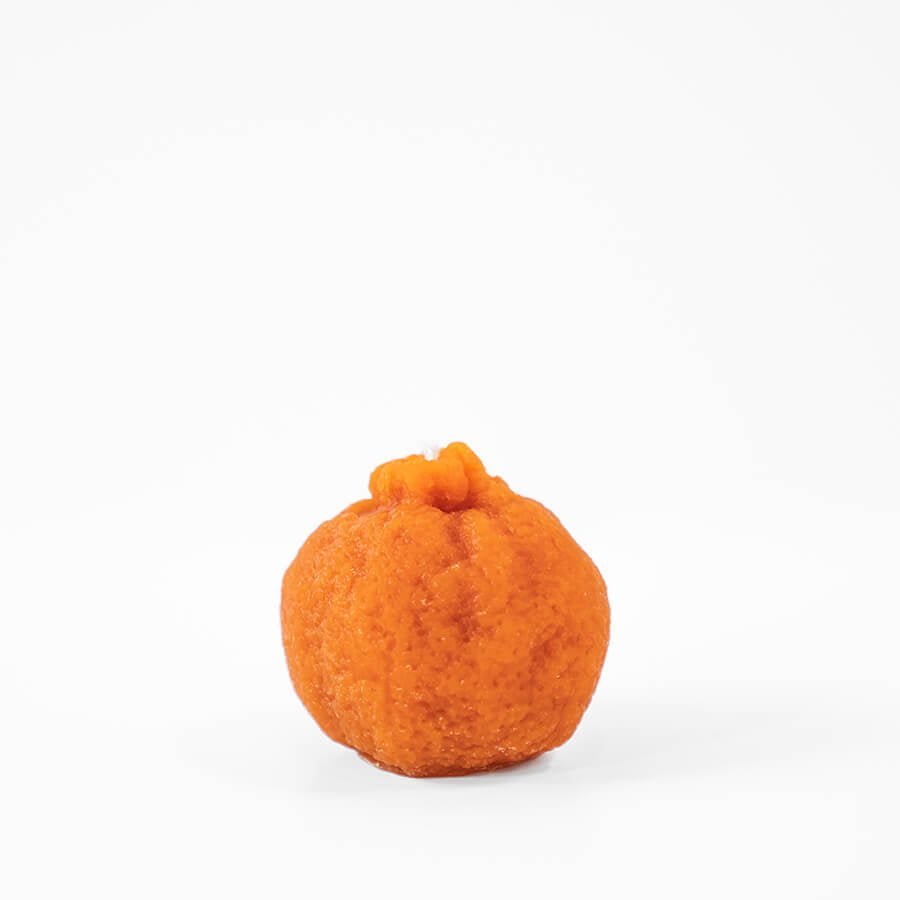 Happy Organics Mandarin Orange Beeswax Candle shaped like a mandarin