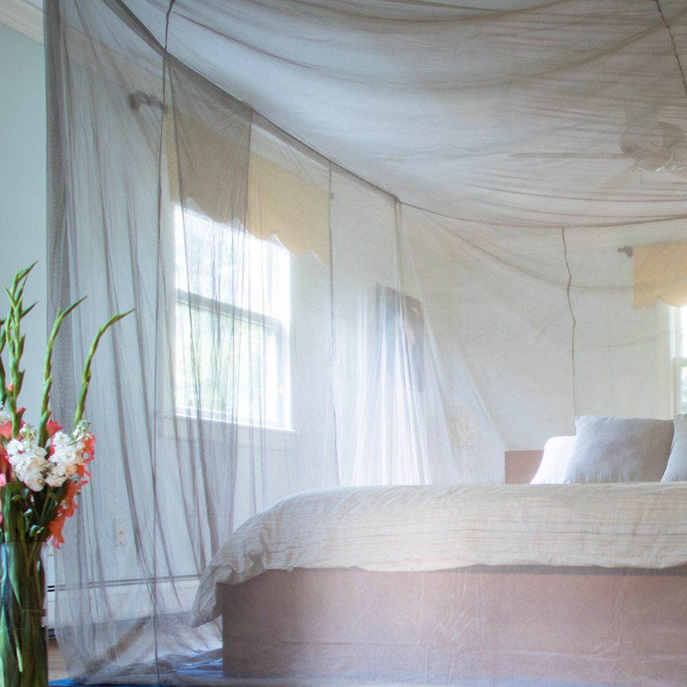 Shield Your Body Faraday Bed Canopy draped over a bed in a bedroom