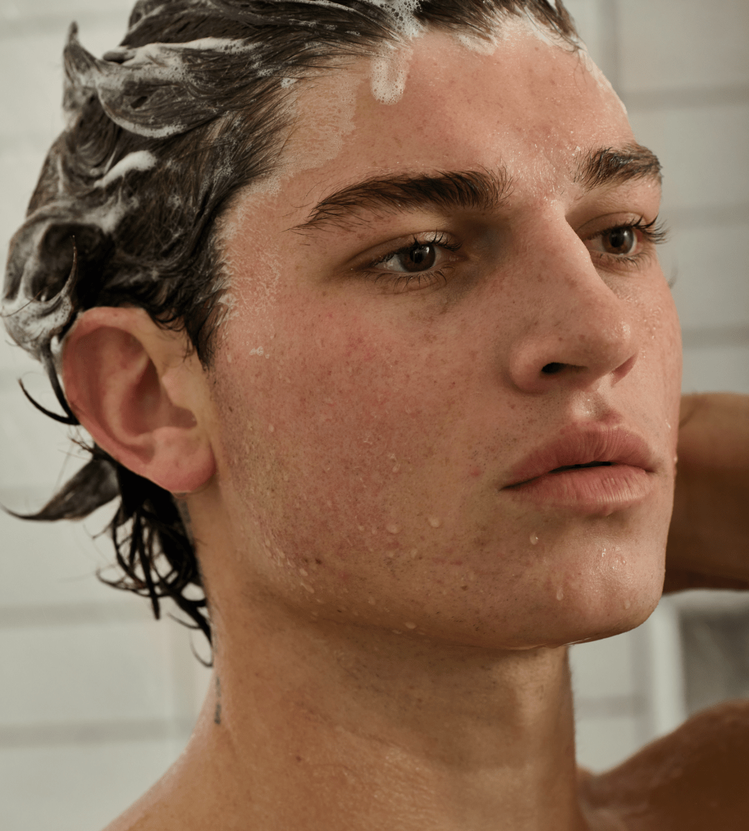 Jack Henry Creamy Shampoo: young man in the shower with shampoo lather in his hair