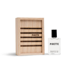 Pirette Fragrance Oil 15 ml bottle beside its wooden gift box with striped lid