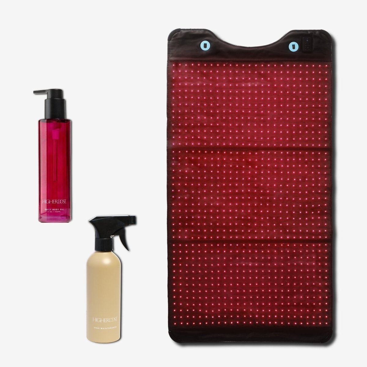 HigherDOSE Full Body Red Light Mat on white beside a Daily Body Oil bottle and a Cleaner spray bottle