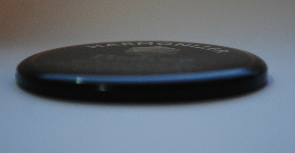 Side edge of the Hedron Life Source Harmonizer disc showing its raised dome