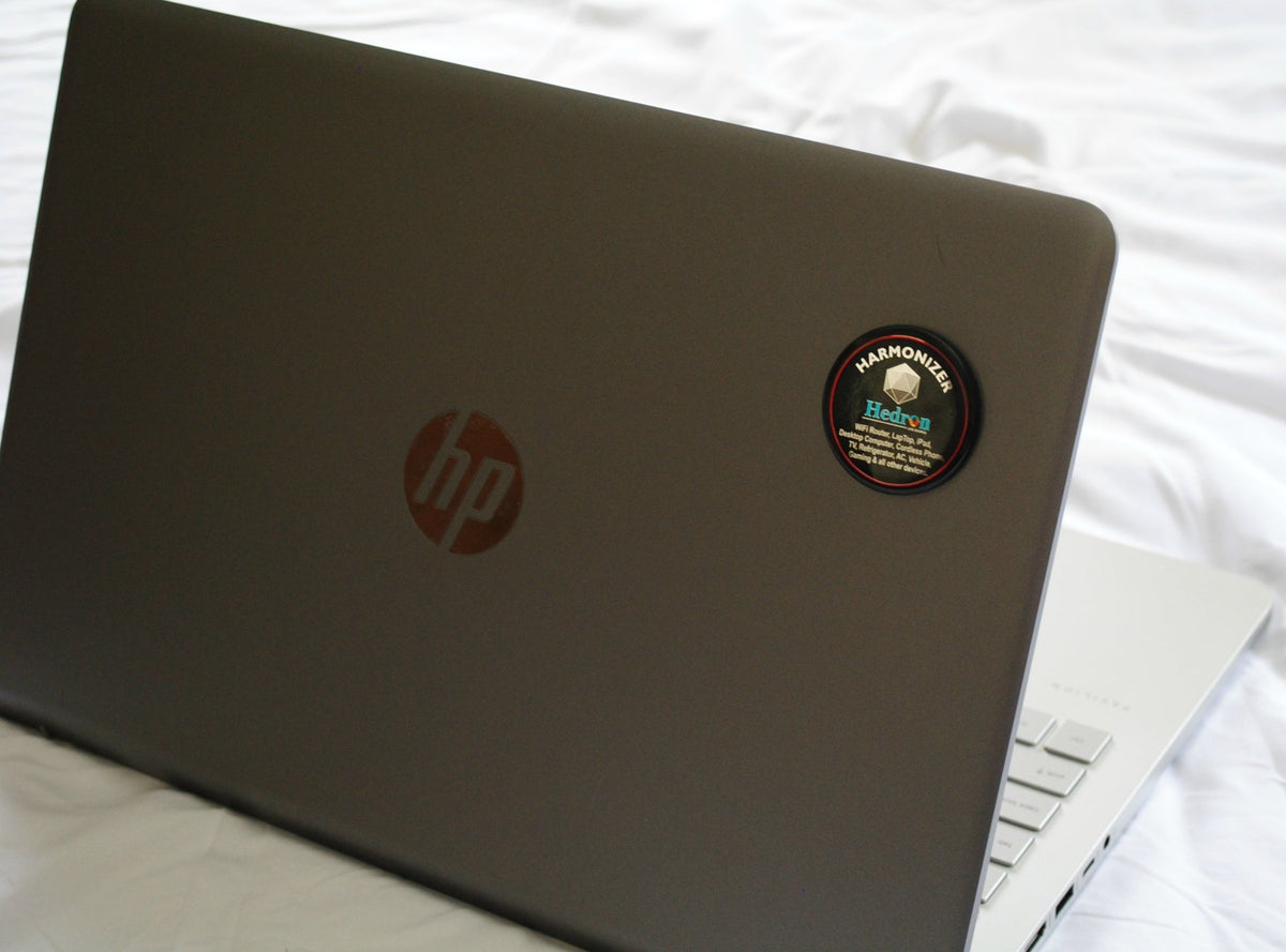 Hedron Life Source Harmonizer sticker on the lid of a gray HP laptop