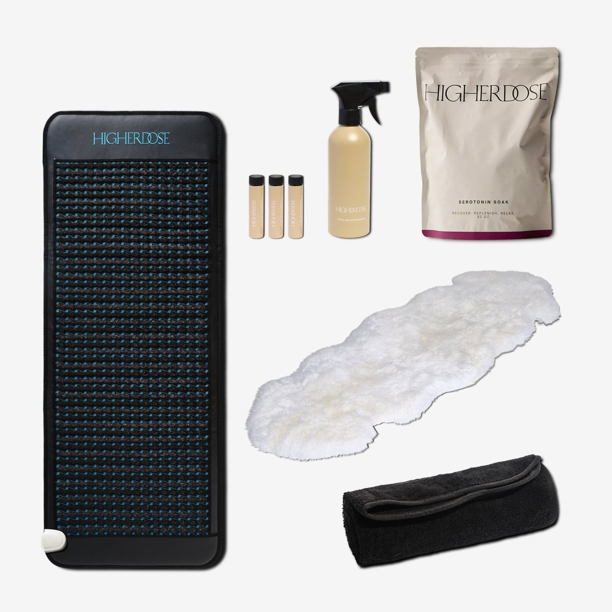 HigherDOSE Infrared PEMF Pro Mat with its Serotonin Soak, cleaner, vials, sheepskin cover and towel topper on white