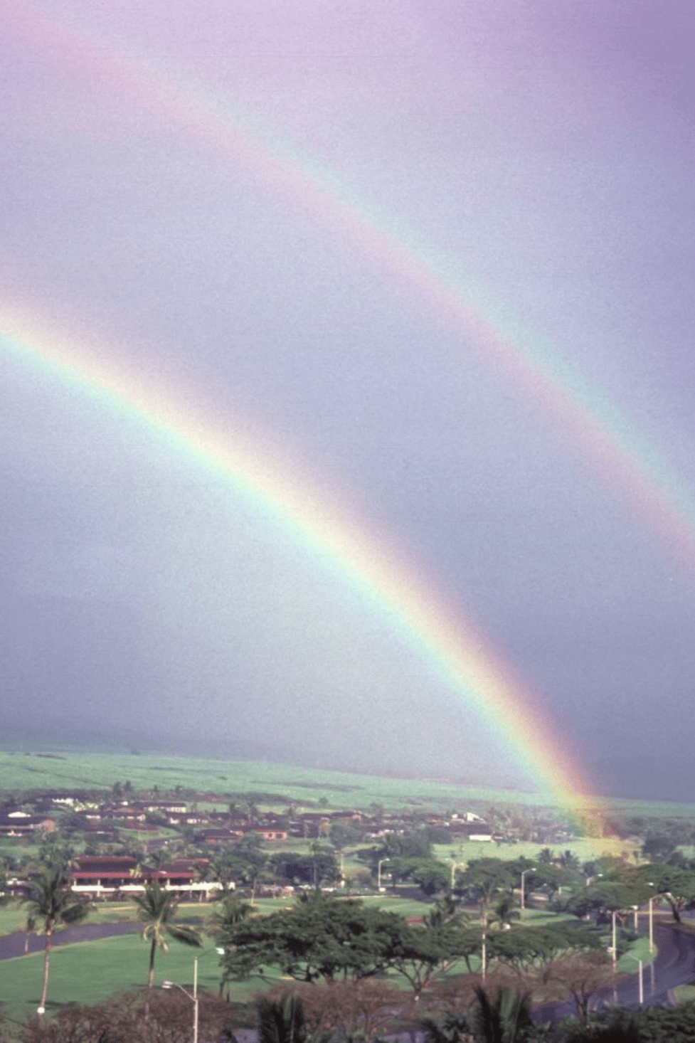 Double rainbow over a green valley and ocean, the Nāmaka scent inspiration from TANAÏS