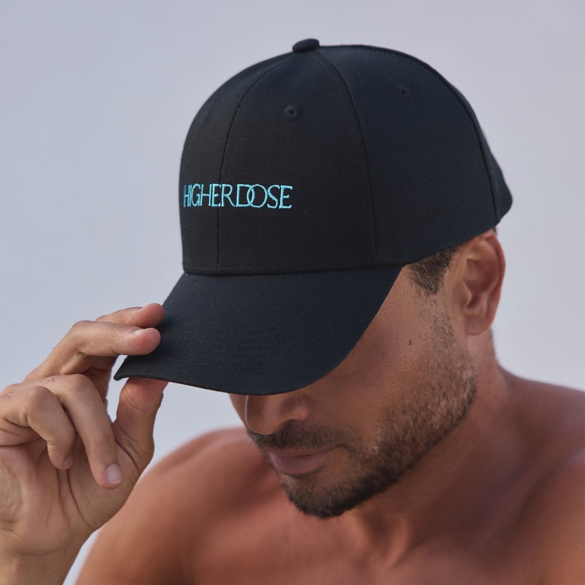 Man wearing the HigherDOSE Red Light Hat tilted down on a beach