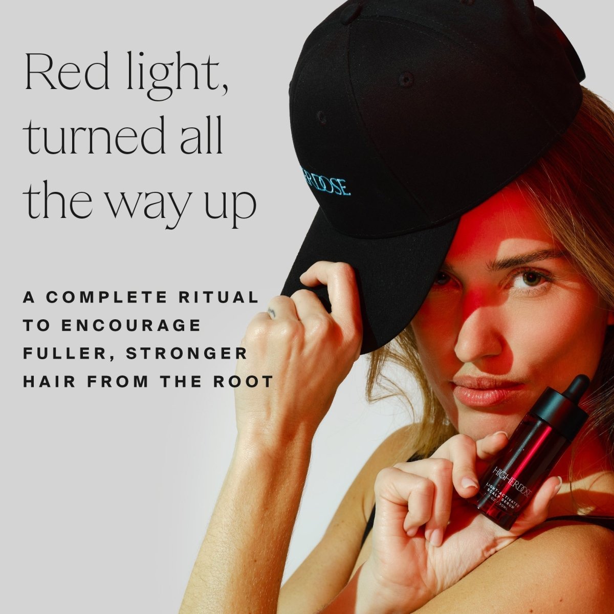 Woman with the HigherDOSE Red Light Hat and a serum bottle: a complete ritual for fuller, stronger hair