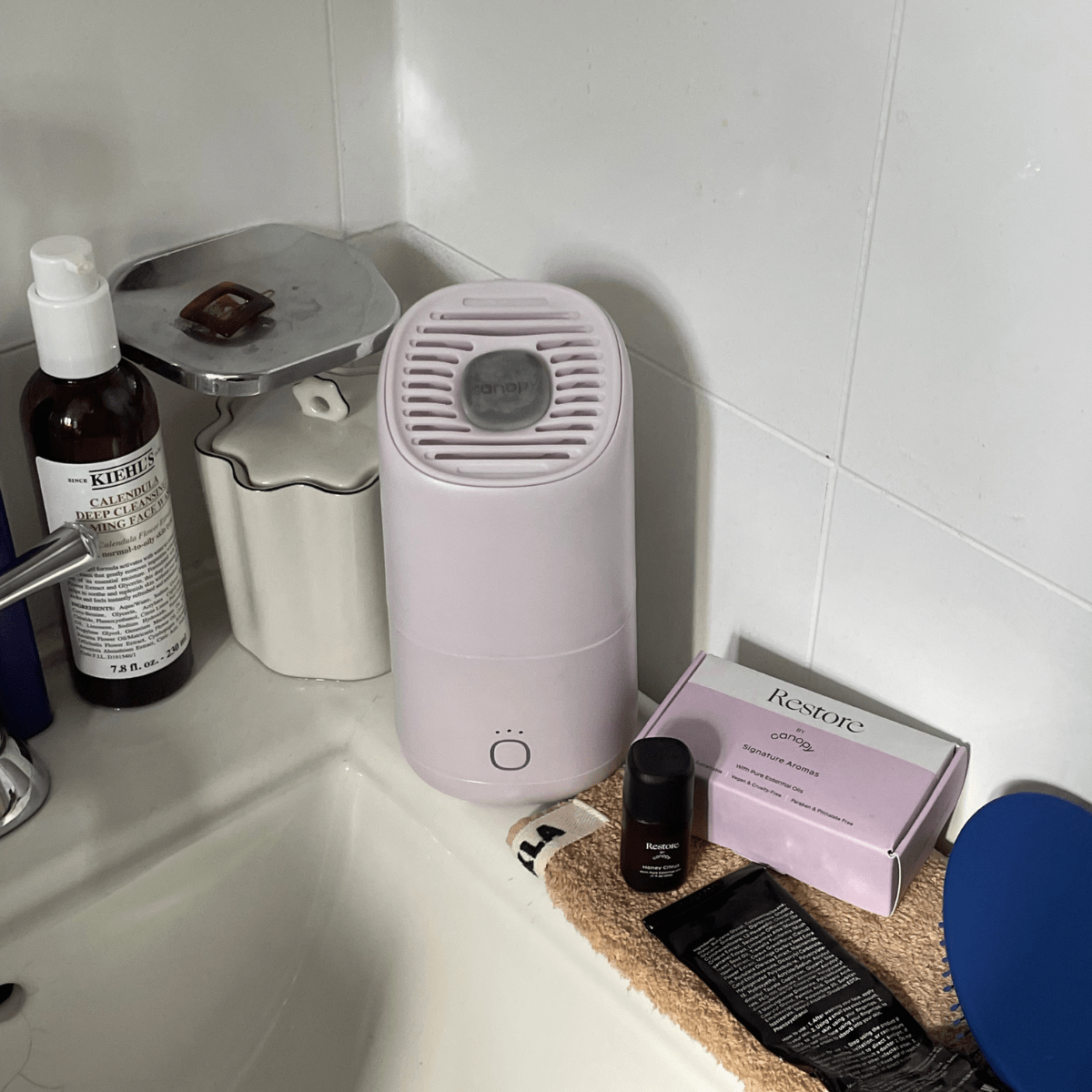 Canopy Restore Aroma Kit and a lavender humidifier beside a sink