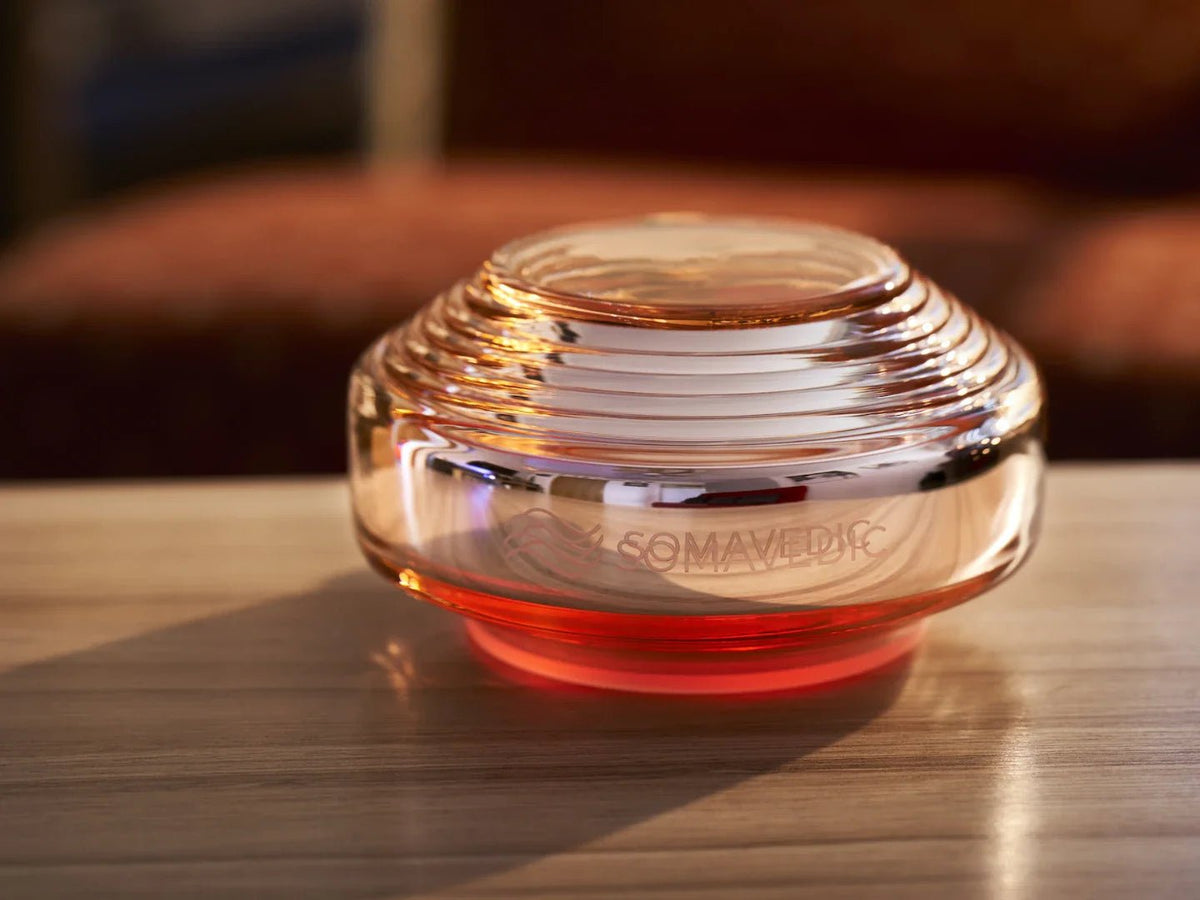Somavedic Rosalin with a coral glow on a wooden table