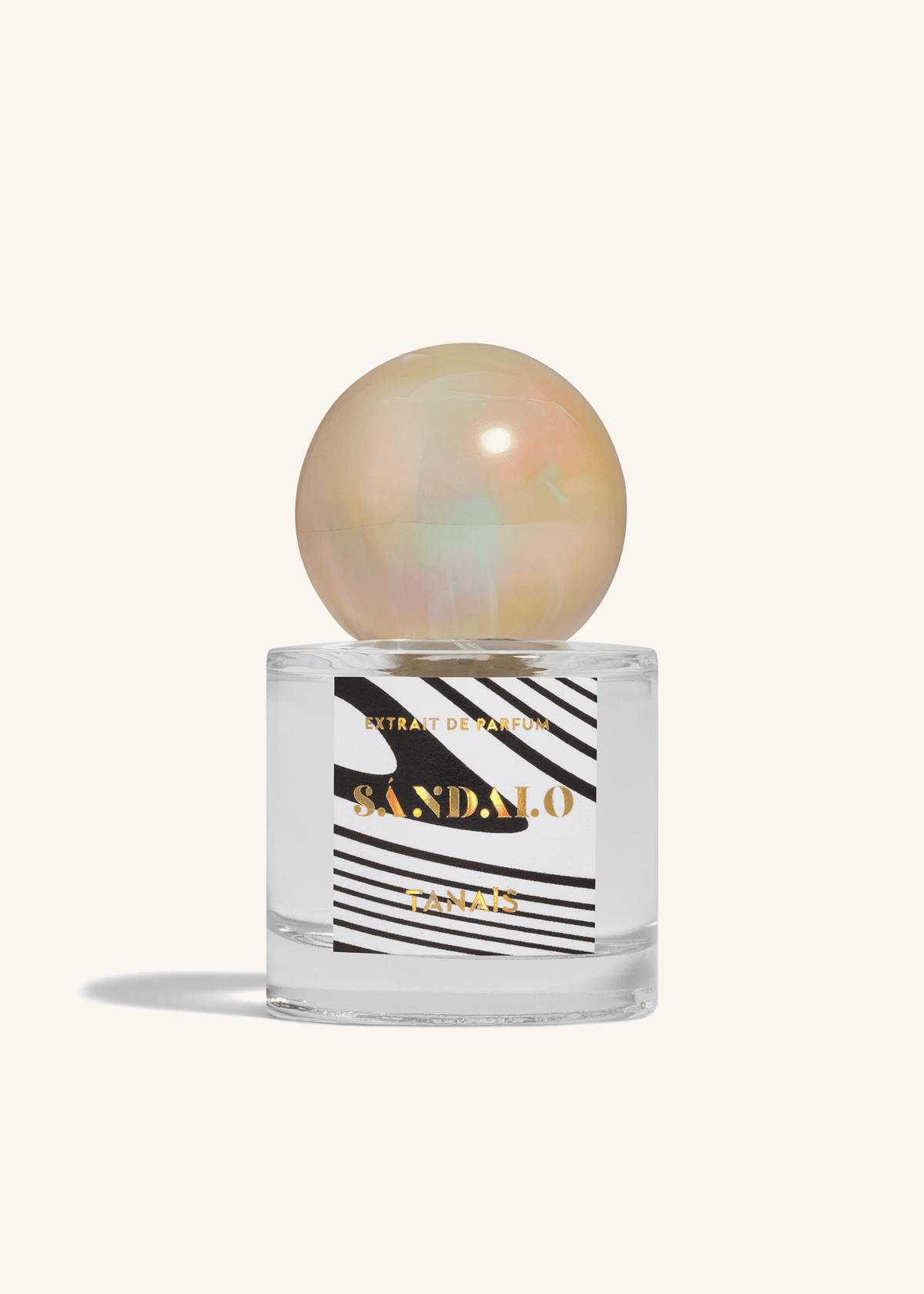 TANAÏS Sándalo Extrait de Parfum bottle with an opalescent pearl cap on a cream background