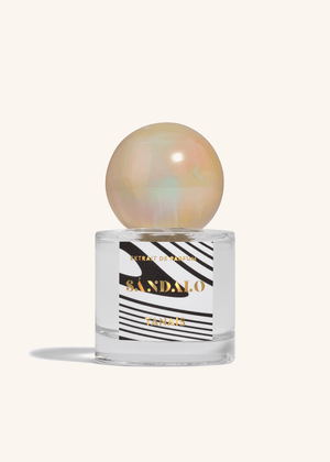 TANAÏS Sándalo Extrait de Parfum bottle with an opalescent pearl cap on a cream background