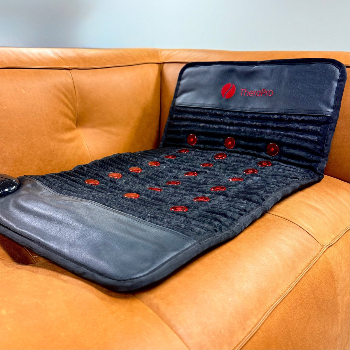 Therasage TheraPro Regular pad laid out on an orange leather couch