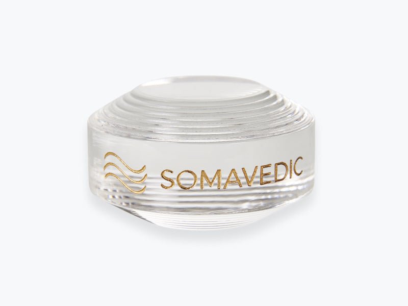 Somavedic Tiny in clear glass with a gold logo on white