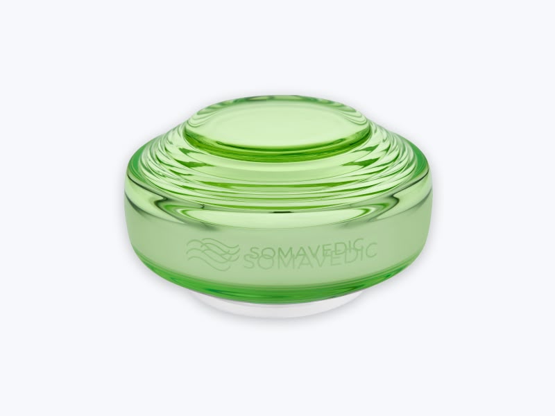 Somavedic Traveller device in green glass with a white base on white