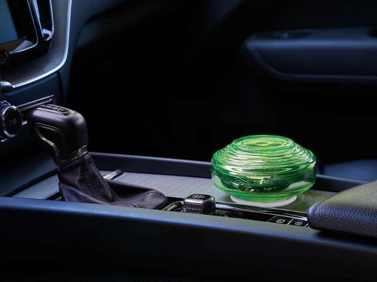 Somavedic Traveller glowing in a dark car beside the gear shift